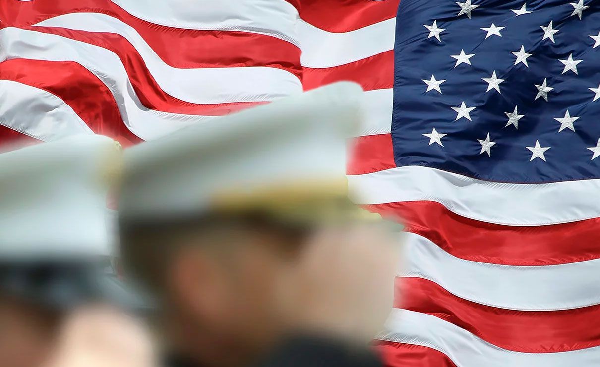 American flag with a US service member saluting in the foreground